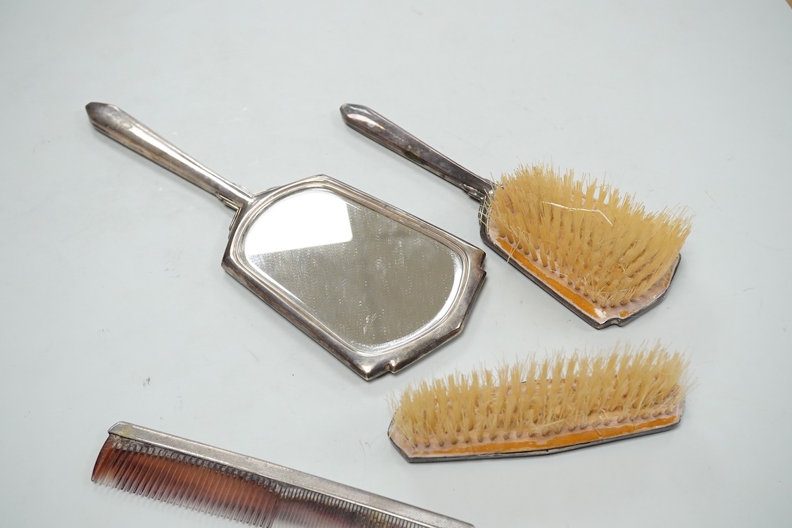 An Elizabeth II engine turned silver Art Deco style four pieced dressing table mirror, brush and comb set, W.I. Broadway & Co, Birmingham, 1961/63/65, mirror 27.8cm.